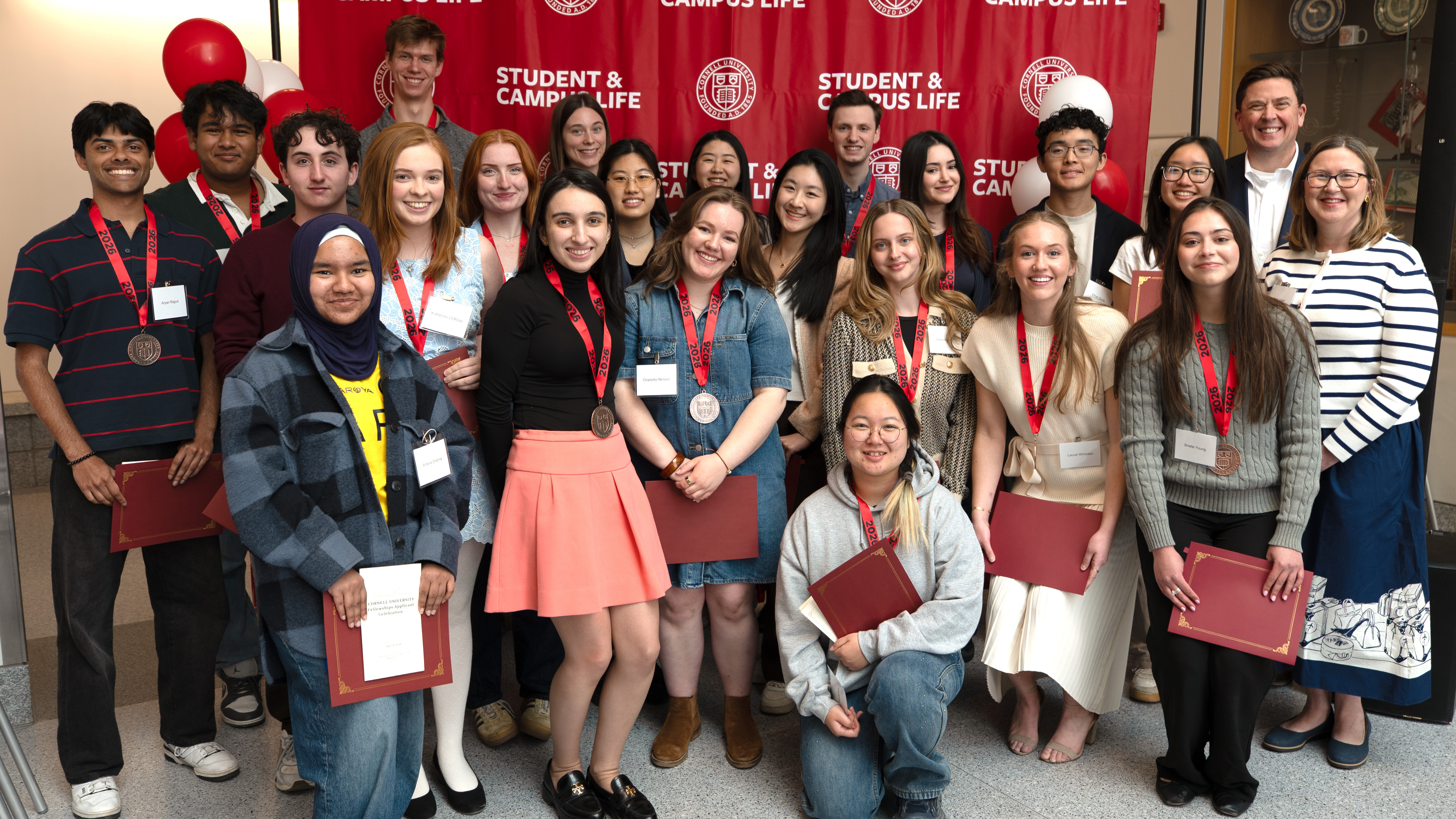 Cornell students and staff pose together with medals and certificates at a Student & Campus Life recognition event.